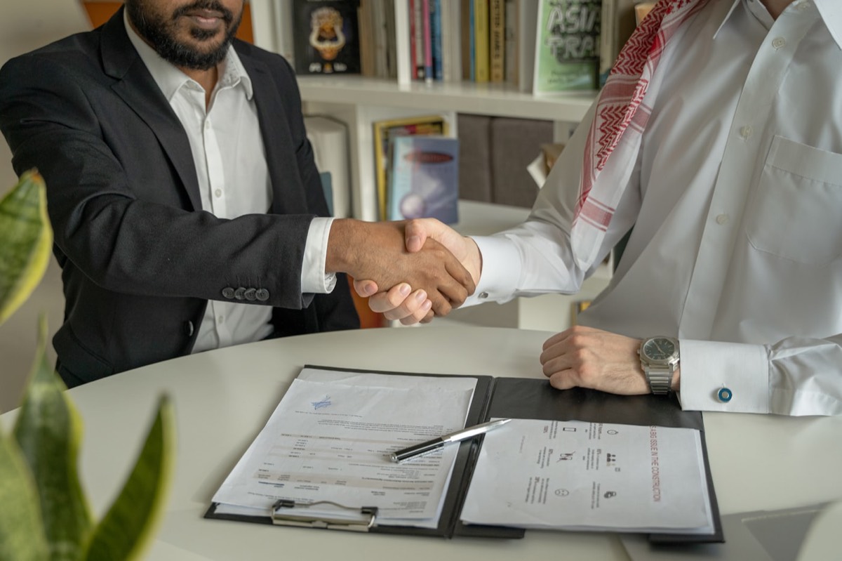 Two business professionals shaking hands after a B2B deal